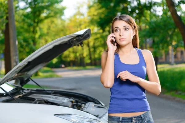Pretty confused girl talking per mobile phone — Stock Photo, Image