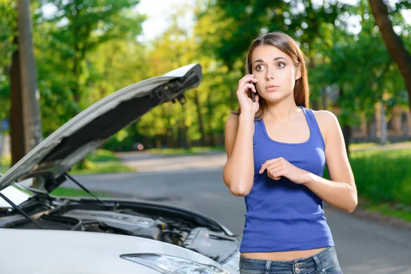 Pretty confused girl talking per mobile phone Royalty Free Stock Photos