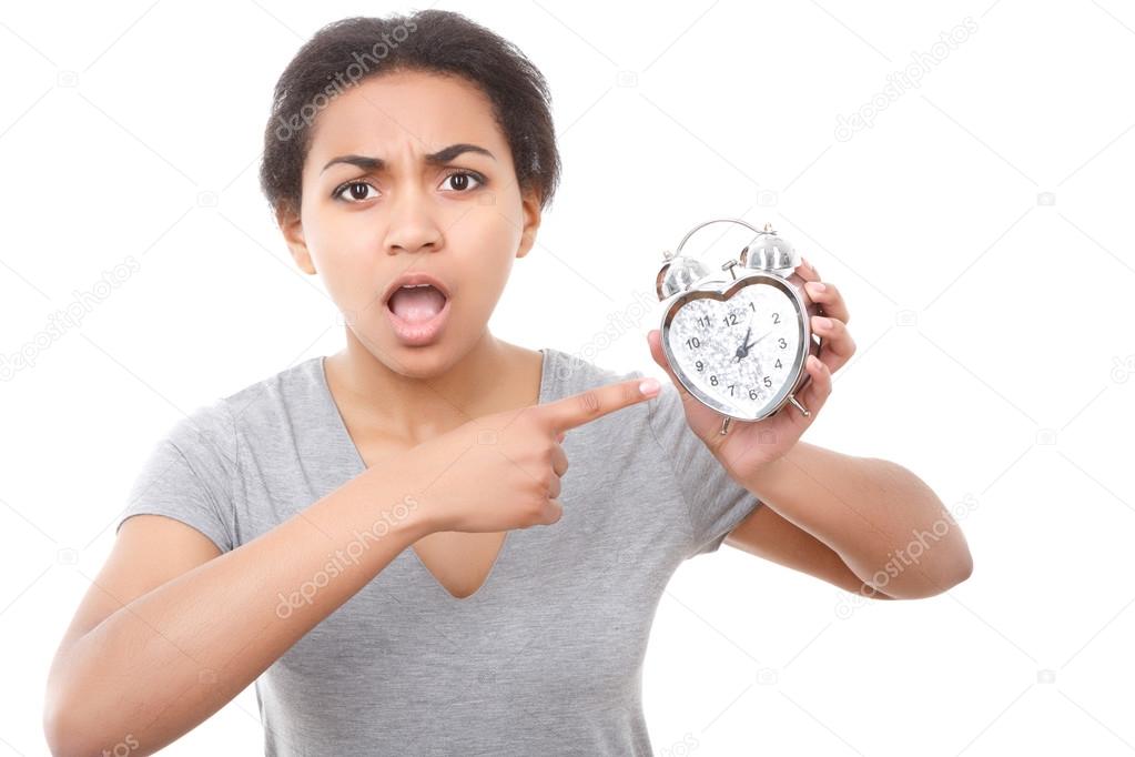 Young mulatto girl posing with alarm clock 