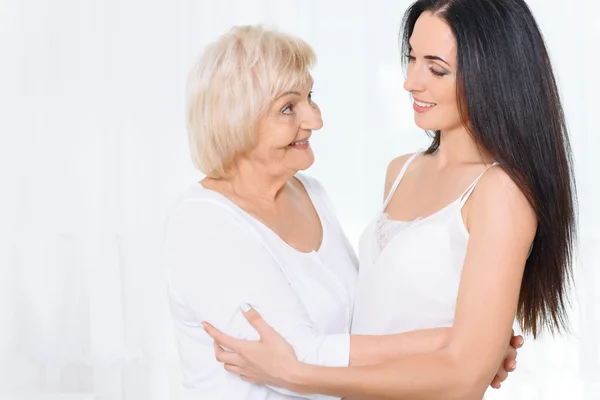 Granny standing and hugging granddaughter — Stock Photo, Image