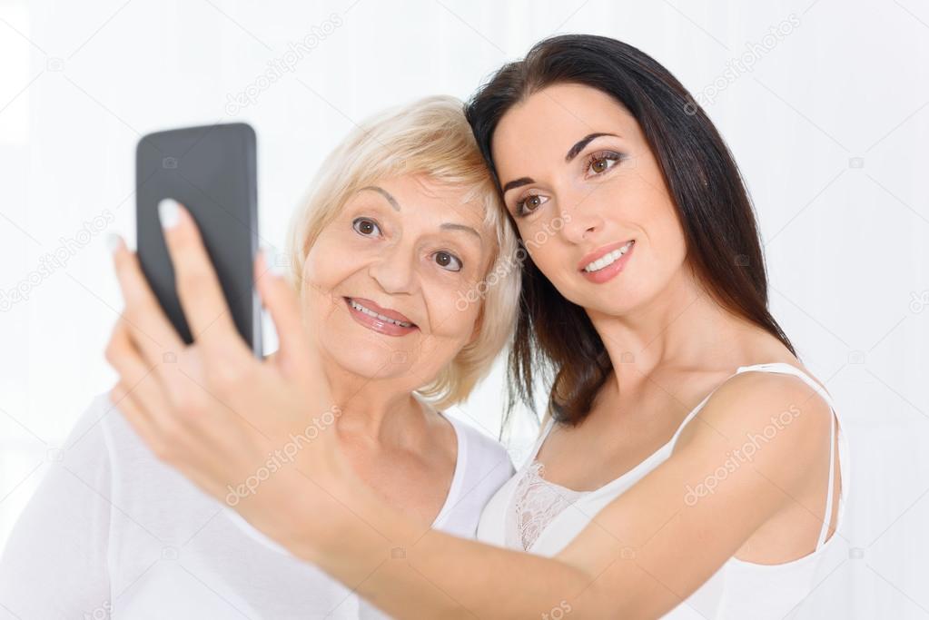 Grandmother and granddaughter doing selfie.