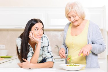 Büyükanne torunu yakınındaki salata karıştırma