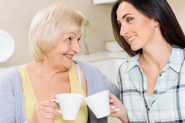 Grandmother and granddaughter drinking tea