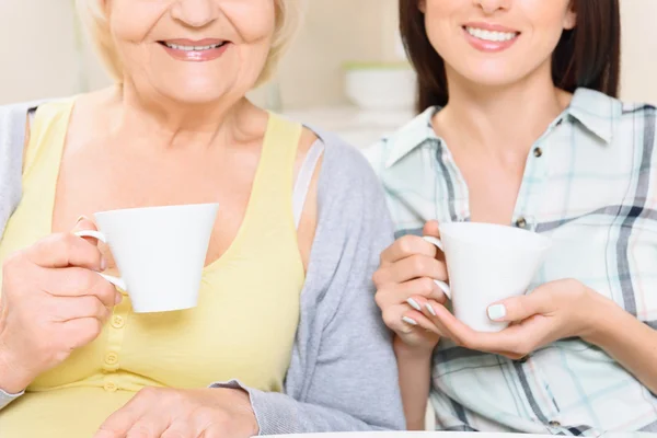 Grootmoeder en kleindochter met cups — Stockfoto
