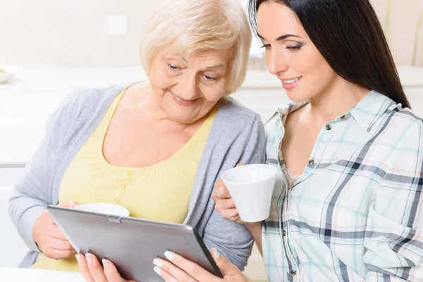 Grandmother and granddaughter looking at tablet — Stock Photo, Image