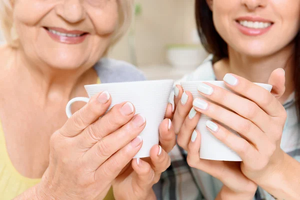 Grandmother and granddaughter with cups — Stock Photo, Image