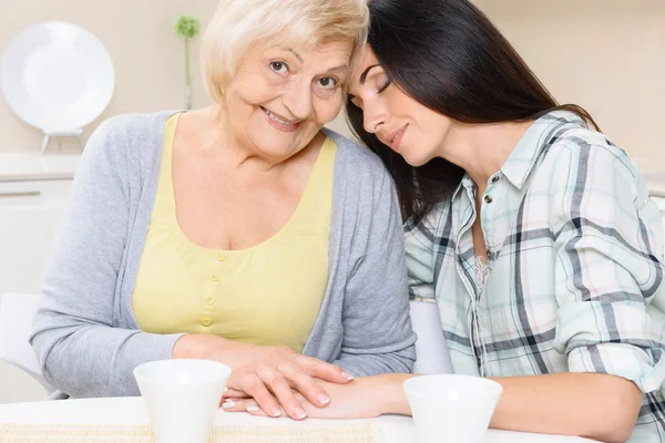 Büyükanne ve torunu mutfakta oturmuş — Stok fotoğraf