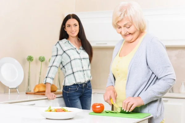 Granny taglio verdure in cucina — Foto Stock