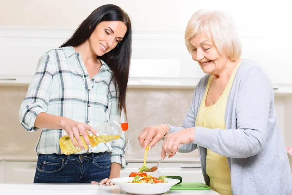 Grootmoeder en kleindochter maken salade — Stockfoto