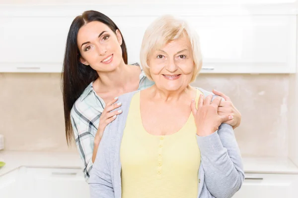 Granddaughter standing behind her granny — Stock Photo, Image