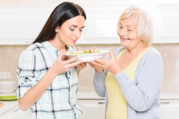 Внучка нюхает салат на кухне — стоковое фото