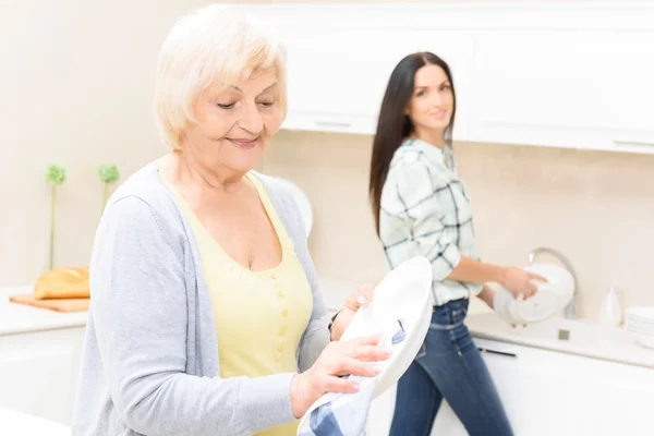 Granddaughter and grandmother washing up — Stock Photo, Image