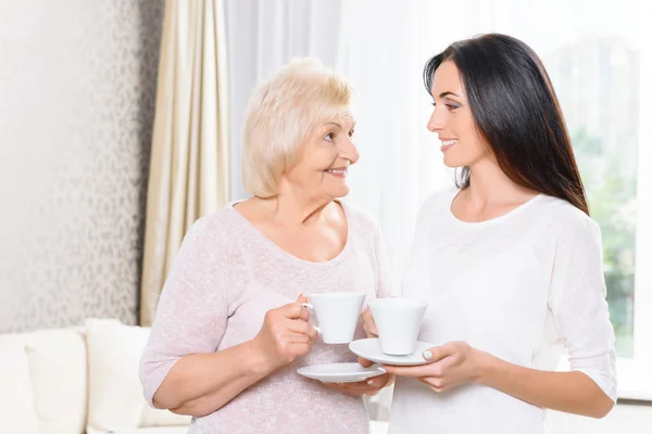 Barnbarn och mormor står med koppar — Stockfoto