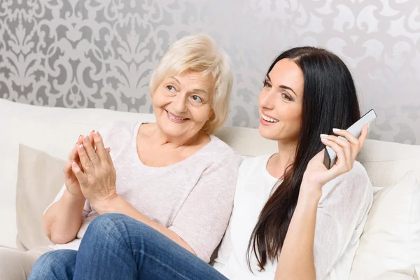 Granddaughter and granny watching TV together — Stock Photo, Image
