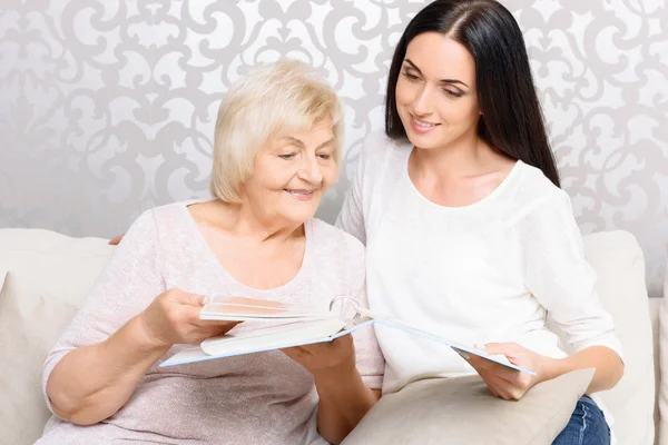 Großmutter mit ihrer Tochter, die Buch hält — Stockfoto