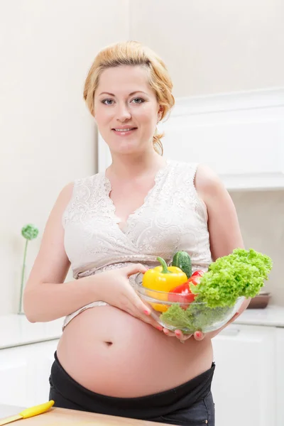 Mujer embarazada de pie en la cocina — Foto de Stock