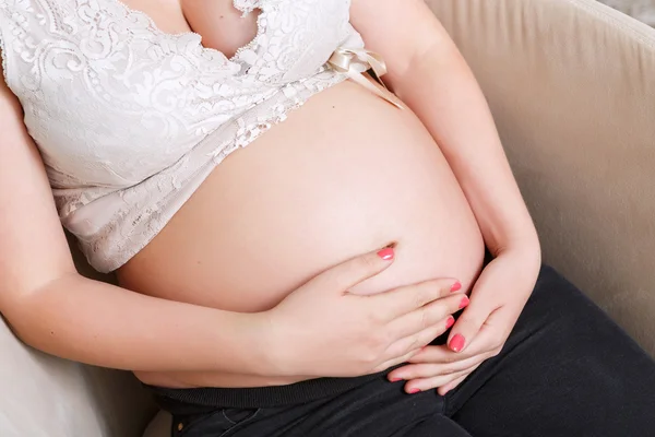 妊娠中の女性、肘掛け椅子に座っています。 — ストック写真