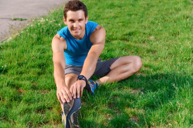 Adam bacağını çimenlerin üzerinde uzanan