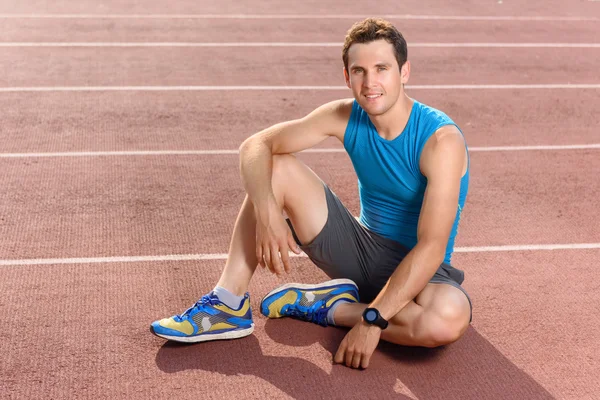 Smiling sportsman sitting and having rest — Stock Photo, Image
