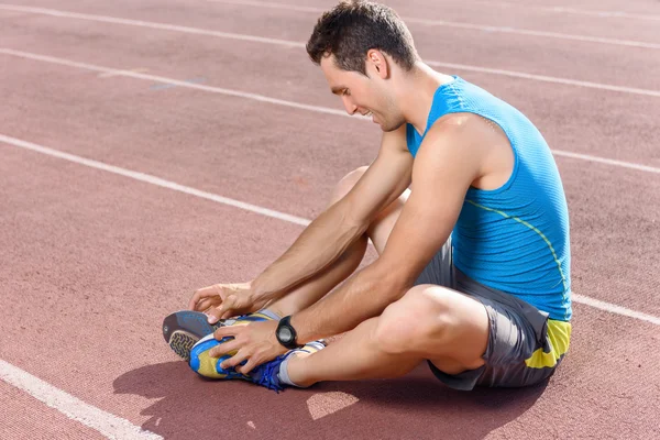 Man sitting and stretching his legs — Stock Photo, Image