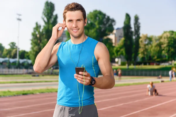 Sportsman de pé com telefone celular no estádio — Fotografia de Stock