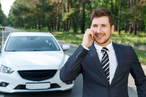 Empresario hablando por teléfono móvil cerca de coche — Foto de Stock