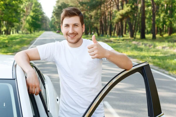 Hombre con barba pulgar hacia arriba cerca del coche —  Fotos de Stock