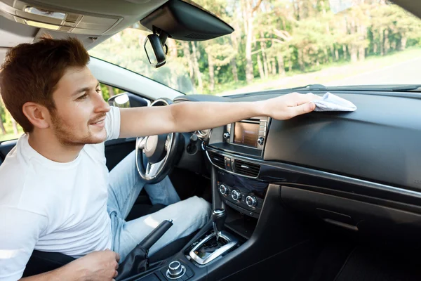 Sonriente hombre limpiando el polvo dentro del coche —  Fotos de Stock