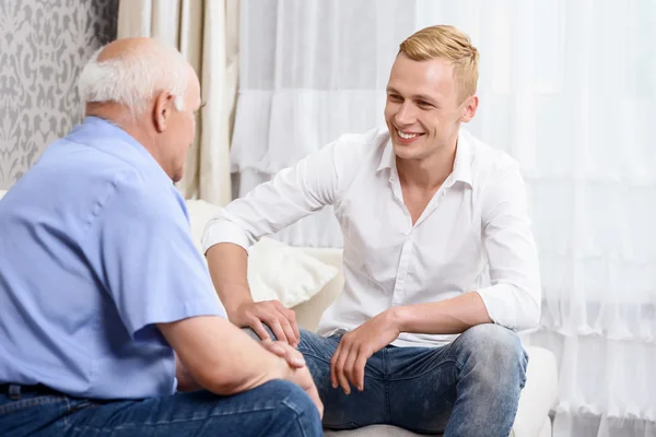 Grandfather and grandson sitting on couch together — Stock Photo, Image