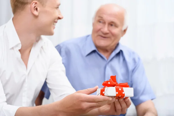 Abuelo y nieto con un pequeño regalo — Foto de Stock