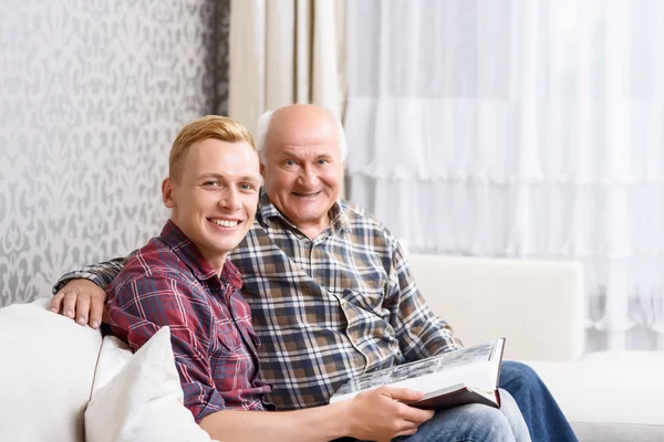 Abuelo y nieto sentado con álbum — Foto de Stock