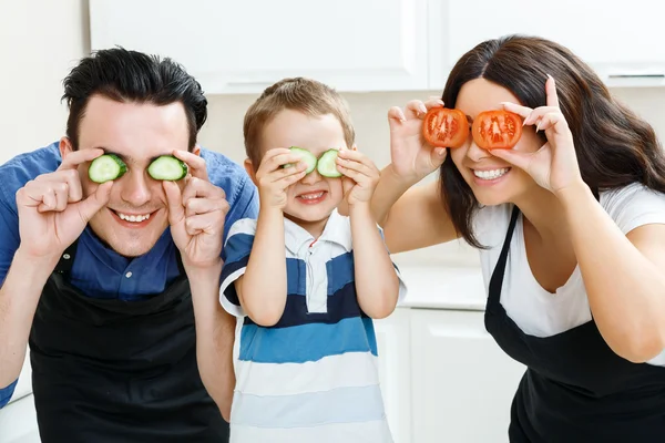 Familia divertida jugando con la comida en la cocina —  Fotos de Stock