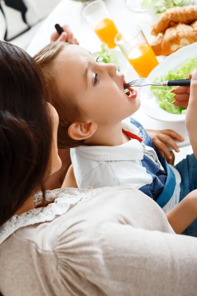 Ung mamma matar sitt barn — Stockfoto