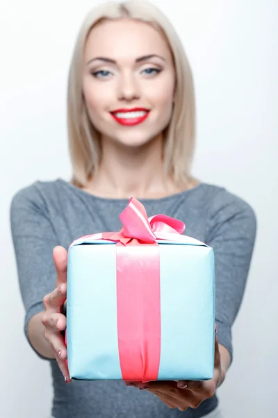 Smiling blond girl giving present — Stock Photo, Image
