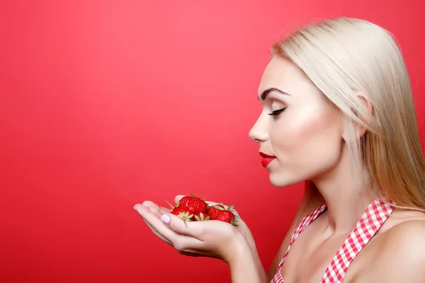 Pretty blond girl holding strawberries — Stock Photo, Image