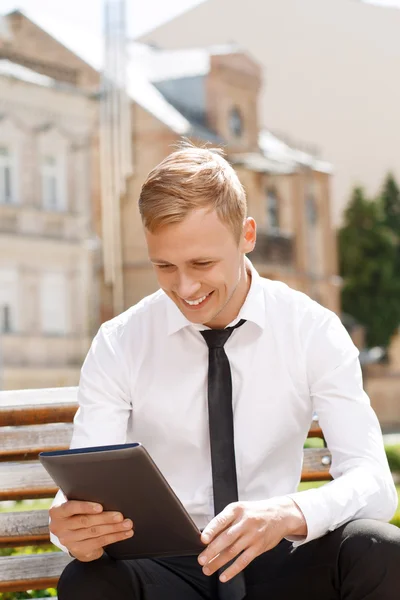 Hombre sonriente usando tableta afuera — Foto de Stock
