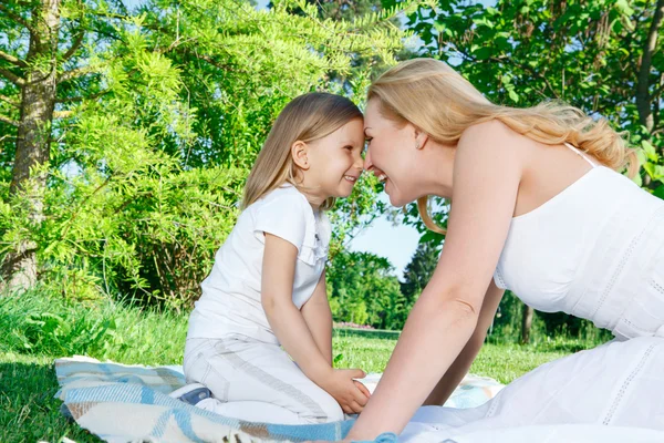 Mother and daughter sitting closely during picnic — Stock Photo, Image