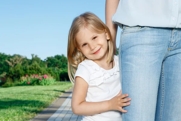 Piccola figlia in piedi vicino alla sua mamma — Foto Stock