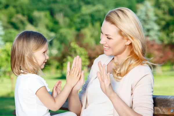 Madre e hija acariciando pastel —  Fotos de Stock