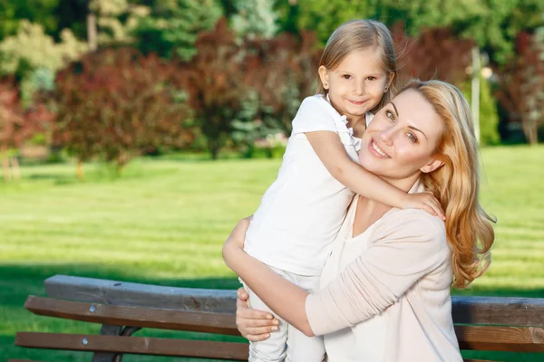 Mother holding her daughter in park — Stock Photo, Image