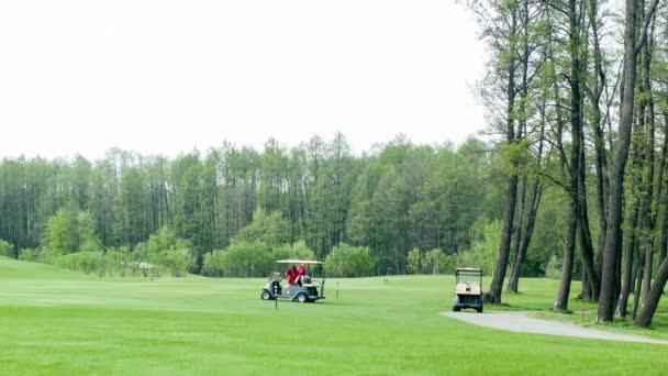 Carros de golfe no campo verde — Vídeo de Stock