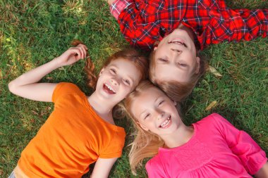 Top view of children lying on the grass 