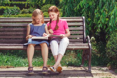 Nice smiling children sitting on the bench 
