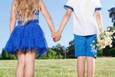 Upbeat little kids holding theur hands together 
