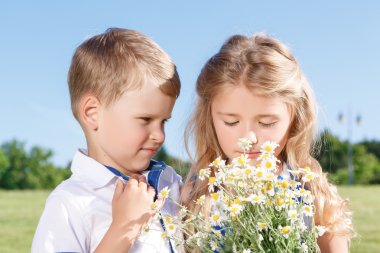 Pretty kids standing with bunch of flowers