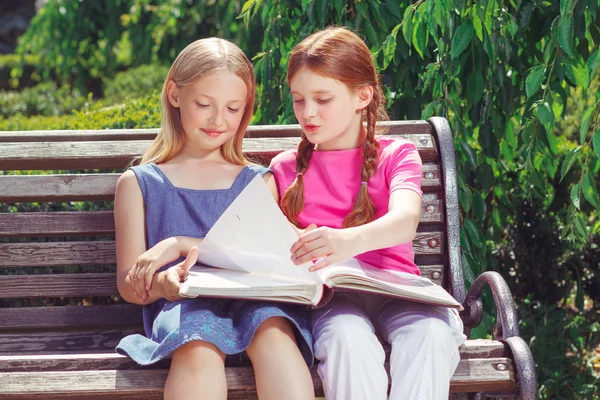 Nice smiling children sitting on the bench — Stok fotoğraf