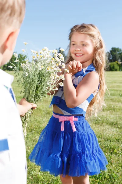 Nice little boy presenting flowers — Stock Photo, Image