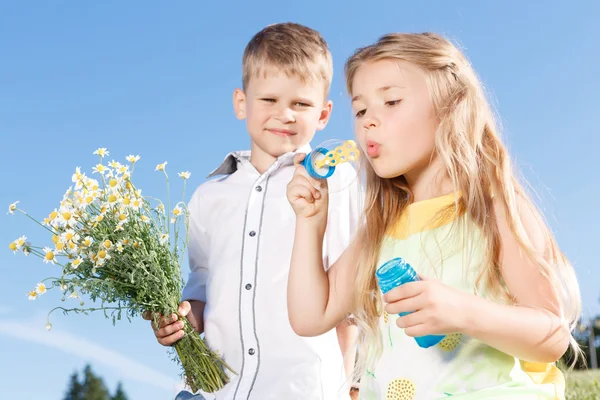 Positive children blowing soup bubbles — Stock Photo, Image