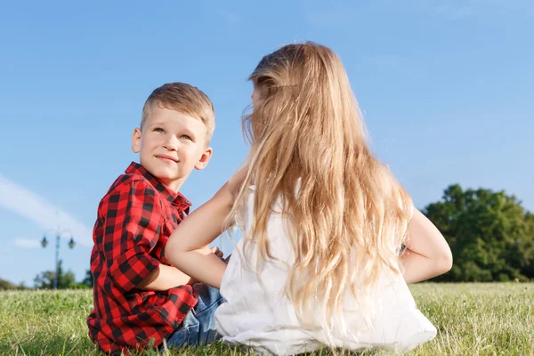 Niza niña y niño sentado al revés —  Fotos de Stock