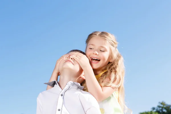 Little girl closing eyes of the boy — Stock Photo, Image